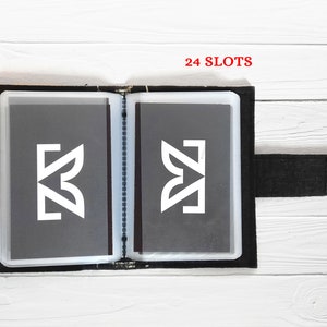 May include: Black card holder with 24 slots, featuring a white logo and a black velcro strap.