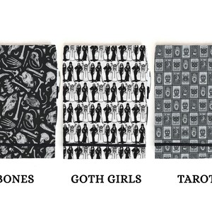 May include: Three black and white patterned notebooks with black elastic closures. The notebooks are labeled "Bones", "Goth Girls", and "Tarots".