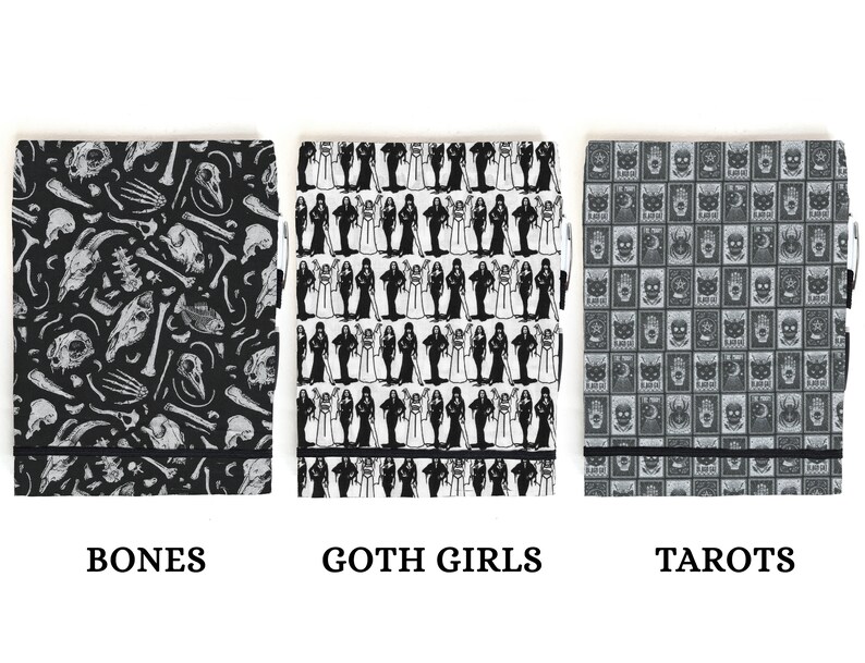 May include: Three black and white patterned notebooks with black elastic closures. The notebooks are labeled "Bones", "Goth Girls", and "Tarots".