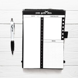 May include: A black and white daily planner with the text "you goth this" on the cover. The planner has a checklist and memo section.
