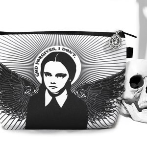 May include: Black and white makeup bag with a graphic of a girl with wings and the text "God Forgives, I Don't".