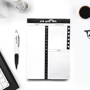 May include: A black and white daily planner with the text "you goth this" and a bat graphic. The planner has sections for date, AM, PM, checklist, and memo.