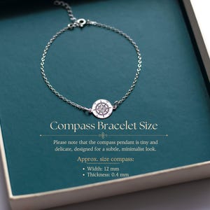 Puede incluir: Una pulsera de cadena plateada con un colgante de br&uacute;jula circular. El texto dice: Compass Bracelet Size. Please note that the compass pendant is tiny and delicate, designed for a subtle, minimalist look. Approx. size compass: Width: 12 mm, Thickness: 0.4 mm.