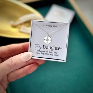 Könnte beinhalten: Eine Halskette mit Kompassanhänger aus Sterlingsilber auf einer weißen Karte. Auf der Karte steht "To my Daughter" und "Wherever life takes you, never forget the way home." Die Halskette ist aus 925er Sterlingsilber.