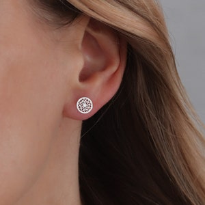 Simple mandala studs in sterling silver on ear