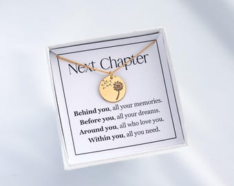 Könnte beinhalten: Eine goldfarbene Halskette mit einem runden Anhänger mit einem Pusteblumen-Design. Die Halskette wird auf einer weißen Karte in einer weißen Box präsentiert. Auf der Karte steht "Next Chapter" und enthält inspirierenden Text.