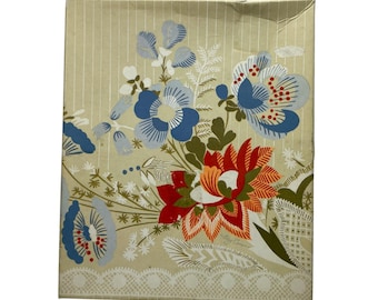 May include: A rectangular box with a light beige background featuring a vertical white pinstripe pattern. The surface displays a floral illustration with large blue, red, and orange flowers, green foliage, and a white lace-like border at the bottom.