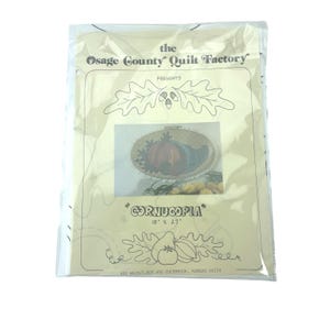 May include: A packaged quilt kit from the Osage County Quilt Factory. The kit features a design labeled "Cornucopia" with dimensions of 18" x 27". The packaging includes an image of a fall-themed embroidery hoop art with pumpkins and gourds.