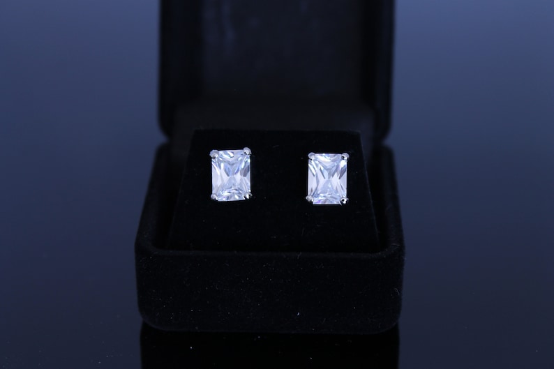 Rhodium plated black velvet box included cubic zirconia pierced earrings Available in 6 different shapes. 8X4 mm clear emerald cut