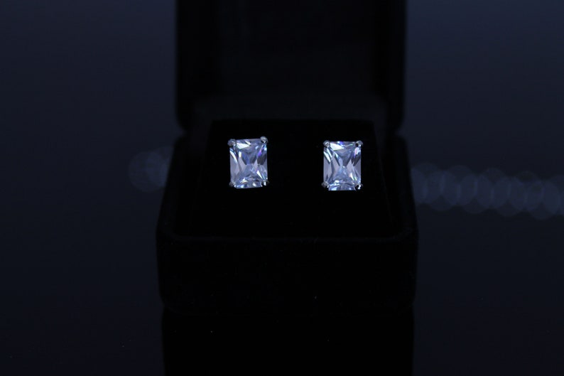 Rhodium plated black velvet box included cubic zirconia pierced earrings Available in 6 different shapes. 8X4 mm clear emerald cut