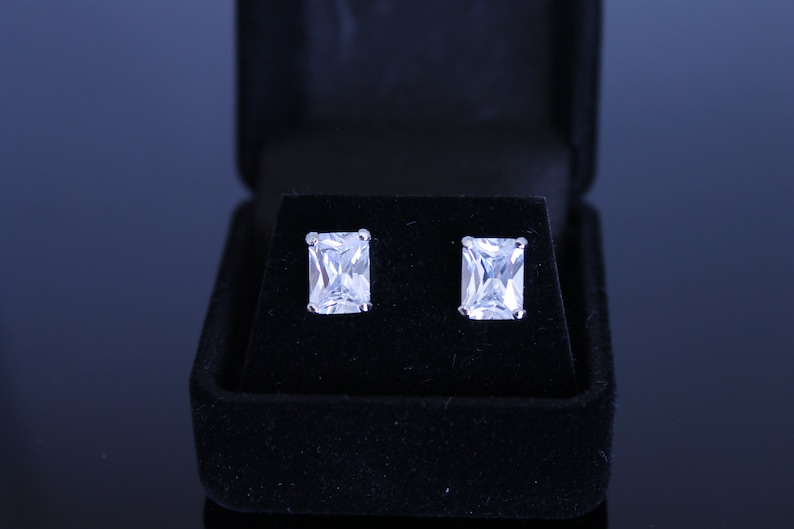 Rhodium plated black velvet box included cubic zirconia pierced earrings Available in 6 different shapes. 8X4 mm clear emerald cut