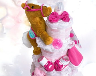 May include: A three-tiered diaper cake decorated with pink and white lace, a brown plush horse toy, pink bows, and a pink and white polka dot blanket. The cake is topped with a clear baby bottle.