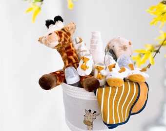 May include: A white fabric basket filled with a stuffed giraffe, baby socks, a bottle, and a bib. The basket has a giraffe design on the front.