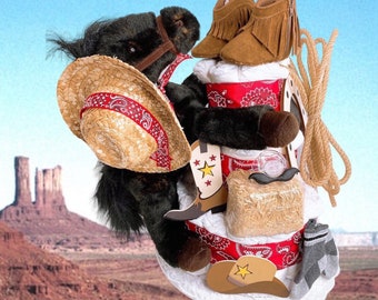 May include: A baby shower diaper cake decorated with a black horse stuffed animal, cowboy boots, and a straw cowboy hat. The cake is wrapped in red and white gingham fabric and has a red and white bandana around the base.