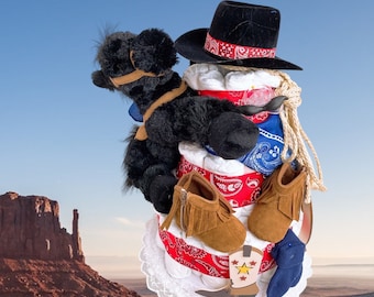 May include: A diaper cake decorated with a black cowboy hat, a black stuffed horse, and red and blue bandana print fabric. The cake is decorated with brown cowboy boots and a white lace trim.