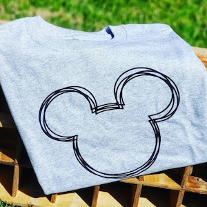 May include: A grey t-shirt with a black outline of Mickey Mouse's head.