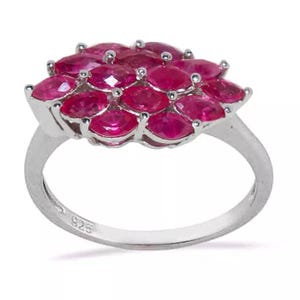 Könnte beinhalten: Ein silberner Ring mit einem Cluster aus marquiseförmigen Rubin-Steinen. Der Ring ist innen mit "925" gekennzeichnet.