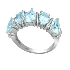 May include: A silver ring with six light blue aquamarine stones set in a prong setting. The ring is a half eternity band style.