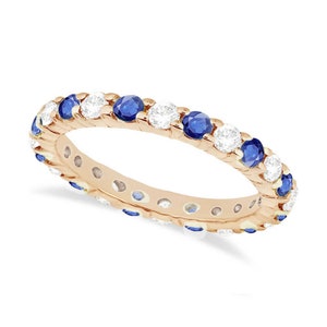 May include: A rose gold eternity band with alternating blue sapphires and white diamonds.