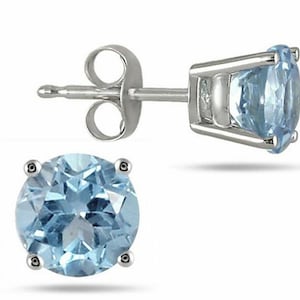 Könnte beinhalten: Ein Paar silberne Ohrstecker mit je einem runden, hellblauen Aquamarin-Edelstein.