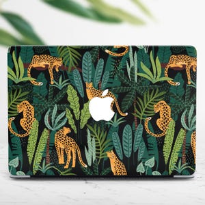 May include: A laptop skin with a jungle pattern featuring orange and black leopards and green leaves on a black background.