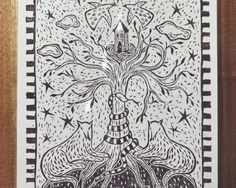 May include: Black and white linocut print of a tree with a house in the branches and two cats sitting at the base of the tree.