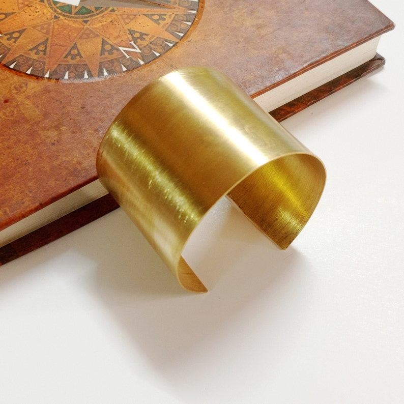 Peut inclure: Un bracelet jonc en or poli simple. Le bracelet est fait d'une seule pi&egrave;ce de m&eacute;tal et a une finition lisse et arrondie.