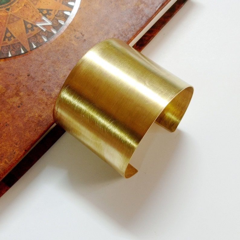 Peut inclure: Un bracelet manchette en m&eacute;tal dor&eacute; avec une finition lisse et bross&eacute;e.
