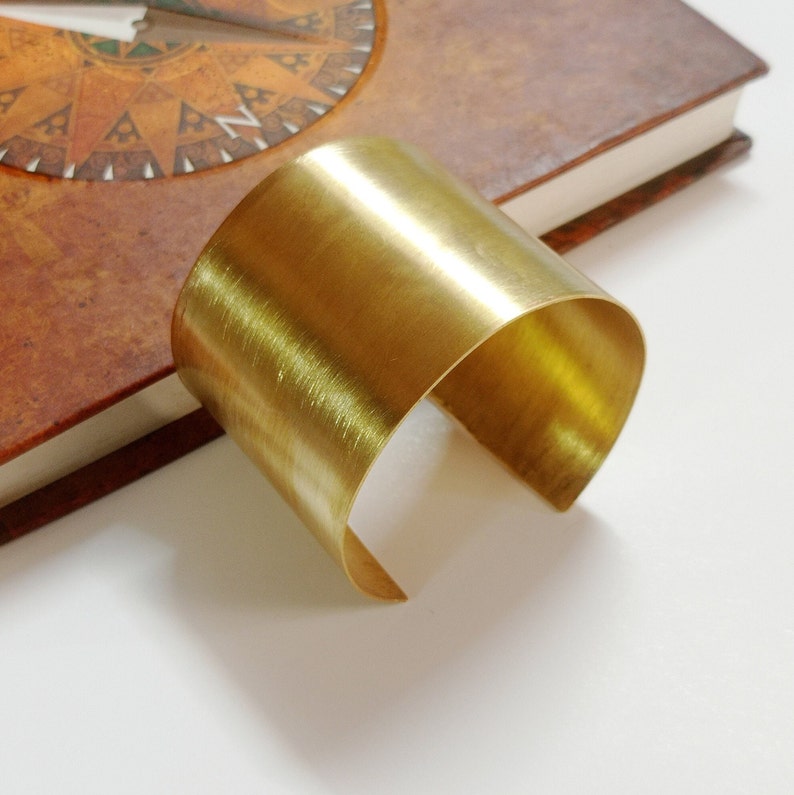 Peut inclure: Un bracelet jonc en laiton poli simple. Le bracelet est &eacute;pais et de forme arrondie.