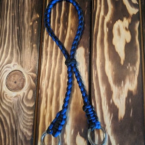 May include: A black and blue braided rope leash with two silver metal rings.