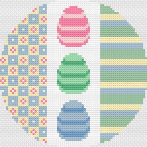 May include: A circular design with three Easter eggs. The top egg is pink and white striped, the middle egg is green and white striped, and the bottom egg is blue and white striped. The background is a patchwork of yellow, blue, and pink squares.