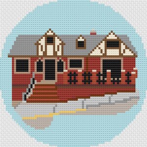 May include: A cross-stitch design of a red house with a gray roof, set against a light blue background. The house features white and brown trim, black windows, and a small chimney. The design is circular.