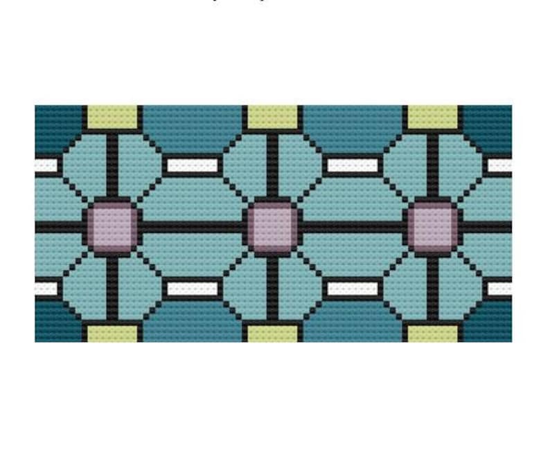 May include: A geometric cross-stitch pattern featuring repeating floral-like shapes. The design uses shades of teal, light blue, and lavender, outlined in black. Small yellow and white accents complete the pattern, which is suitable for various craft projects.