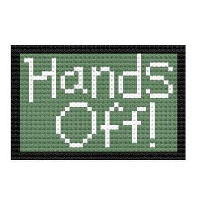 May include: A cross-stitch design on a green background with the words "HANDS OFF!" in white. The text is framed by a black border, creating a simple, yet bold statement.