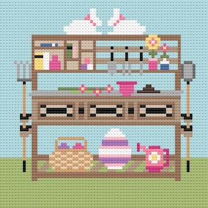May include: A cross-stitch pattern featuring a brown wooden potting bench against a light blue sky and green grass. The bench holds two white bunnies, gardening tools, flowers in pots, a woven basket, a striped egg, and a pink watering can.