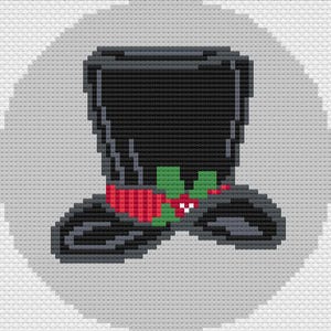 May include: A pixel art style cross stitch pattern of a black top hat. The hat features a red band decorated with green holly leaves and small red berries with white highlights. The design is set against a light gray circular background.