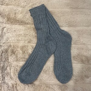 May include: A pair of gray knitted socks with a ribbed texture.
