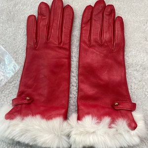 May include: A pair of red leather gloves with white fur trim. The gloves have a gold button detail on the wrist.