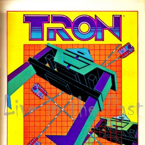 May include: A vintage video game advertisement for TRON Deadly Discs and Adventures of TRON for the Atari 2600. The ad features a colorful, geometric design with a grid pattern and a light blue, purple, and green Tron lightcycle.
