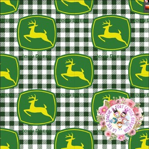 Pode incluir: Um padrão sem costura com um logotipo John Deere verde e amarelo com um veado saltando sobre um fundo xadrez branco e verde.