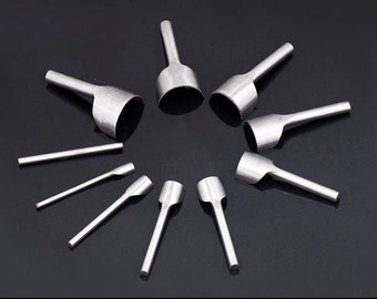 May include: A set of ten silver leather hole punches of varying sizes. The punches are arranged in a circle on a black surface.
