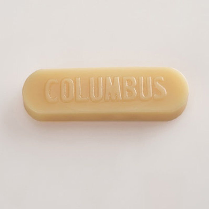 K&ouml;nnte beinhalten: Ein beigefarbener Schuhputzstift mit dem Wort "COLUMBUS" in Pr&auml;gung auf der Oberseite.