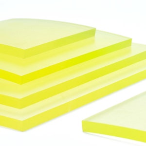 May include: Stack of five translucent yellow acrylic sheets, with one sheet angled in the foreground.