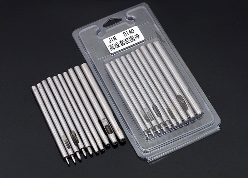 May include: A set of 12 silver metal hole punch tools in a clear plastic package. The package has the text "JIN DIAO 高级套装 圆形" printed on it.