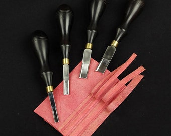May include: Four black handled leather working tools with metal blades, arranged on a pink leather surface.