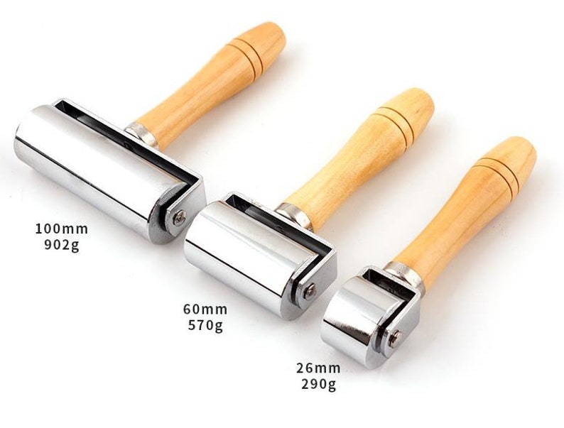 May include: Three metal rolling tools with wooden handles. The rollers are 100mm, 60mm, and 26mm in diameter. The weights are 902g, 570g, and 290g.