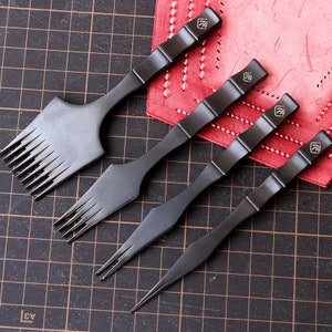 May include: Four black leather crafting tools with bamboo handles. The tools have different tips, including a stitching awl, a pricking tool, and a stitching chisel.