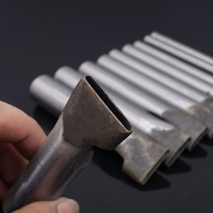May include: A set of metal tools with rectangular openings, likely used for leather crafting. The tools are silver in color and have a slightly worn appearance.