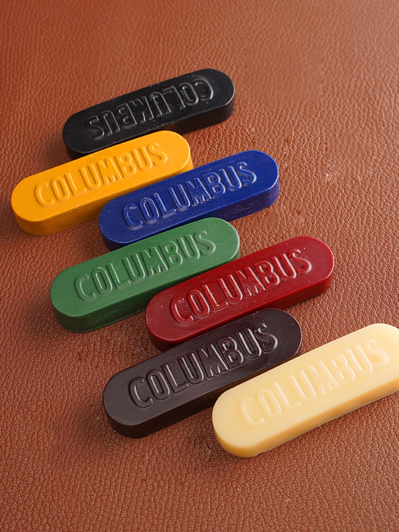 K&ouml;nnte beinhalten: Sechs Siegelwachsst&auml;be in verschiedenen Farben: Schwarz, Gelb, Blau, Gr&uuml;n, Rot und Creme. Jeder Stab hat das Wort "COLUMBUS" gepr&auml;gt.