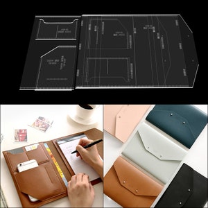 May include: A brown leather notebook with multiple pockets and a phone slot. The notebook is open and a hand is writing on the paper. The notebook is on a white surface with a cup of coffee and a few photos.
